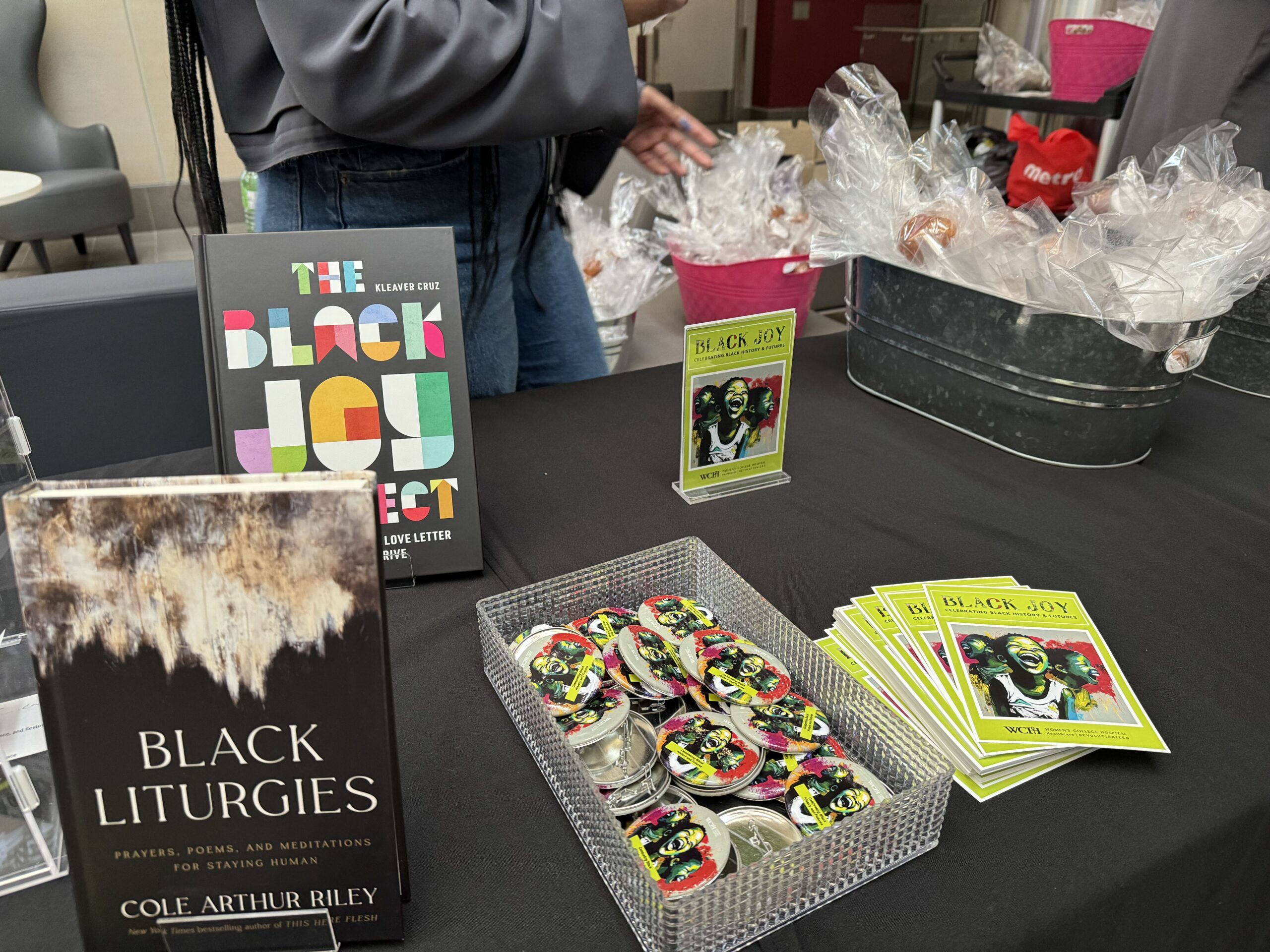 Photo of Black History Futures Month swag including 'Black Joy' buttons, 'Black Liturgies' book and 'The Black Joy Project' book