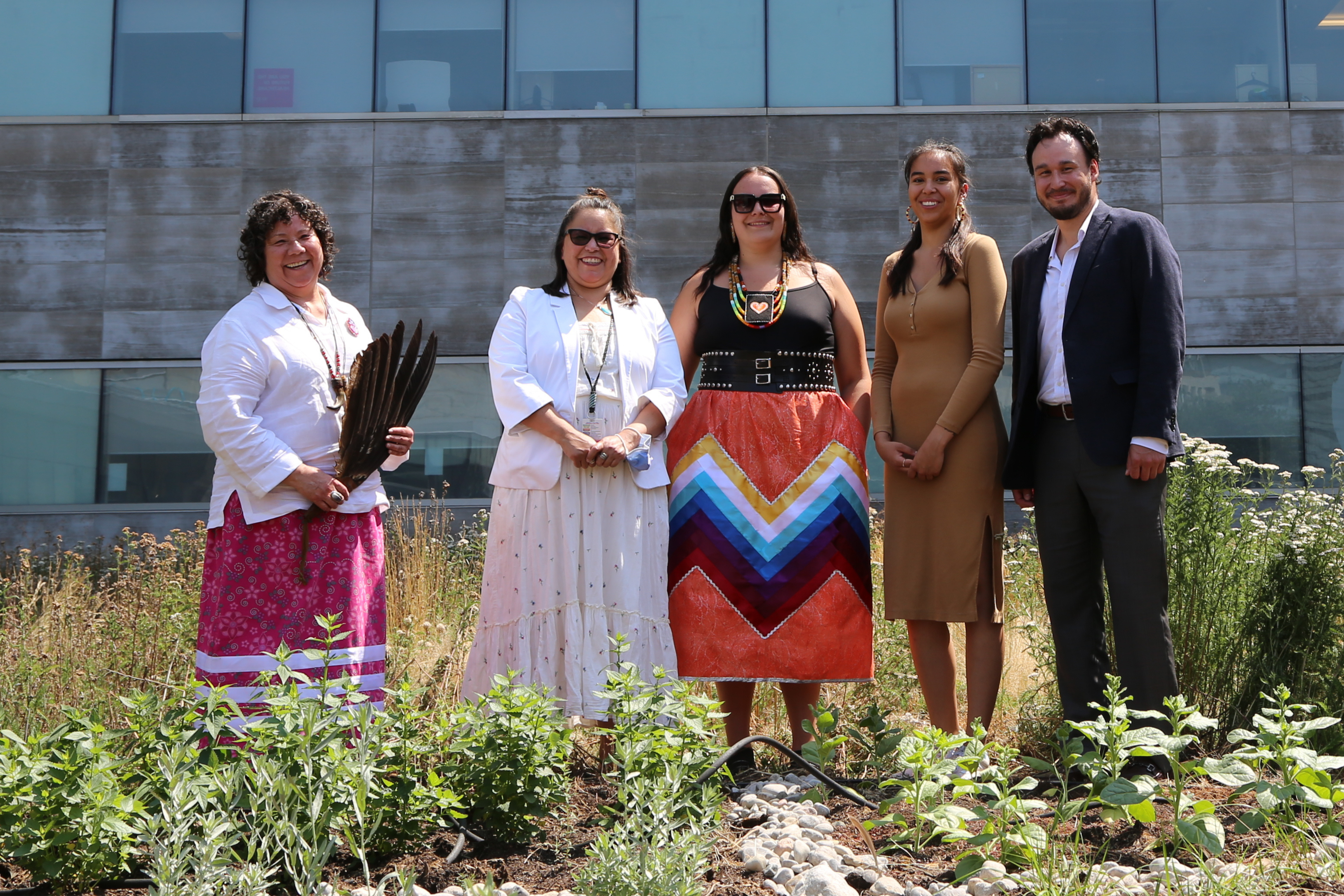 Centre for Wise Practices and Indigenous Health team standing and smiling by medicine garden 