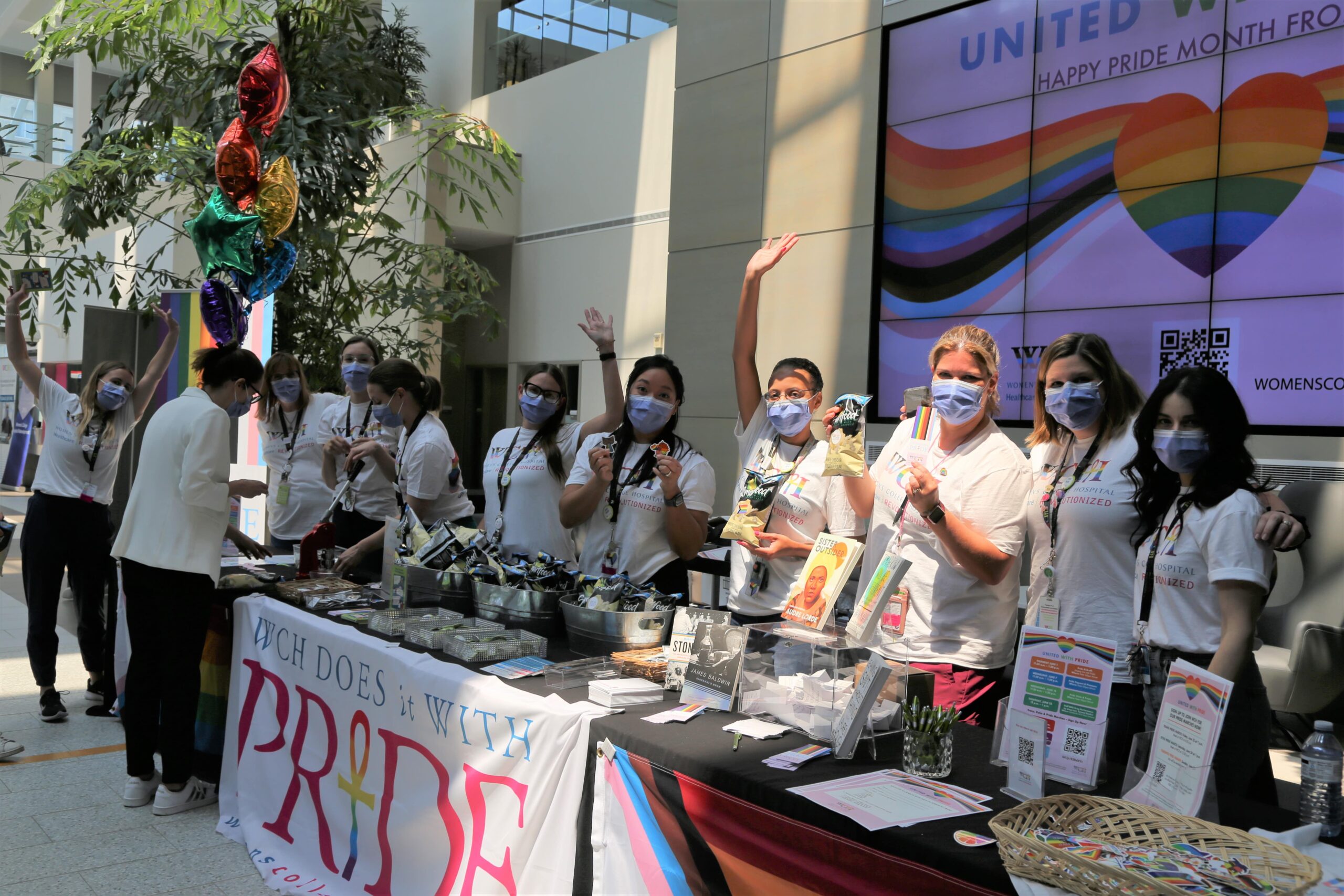 Group photo of WCH employees at Pride booth 