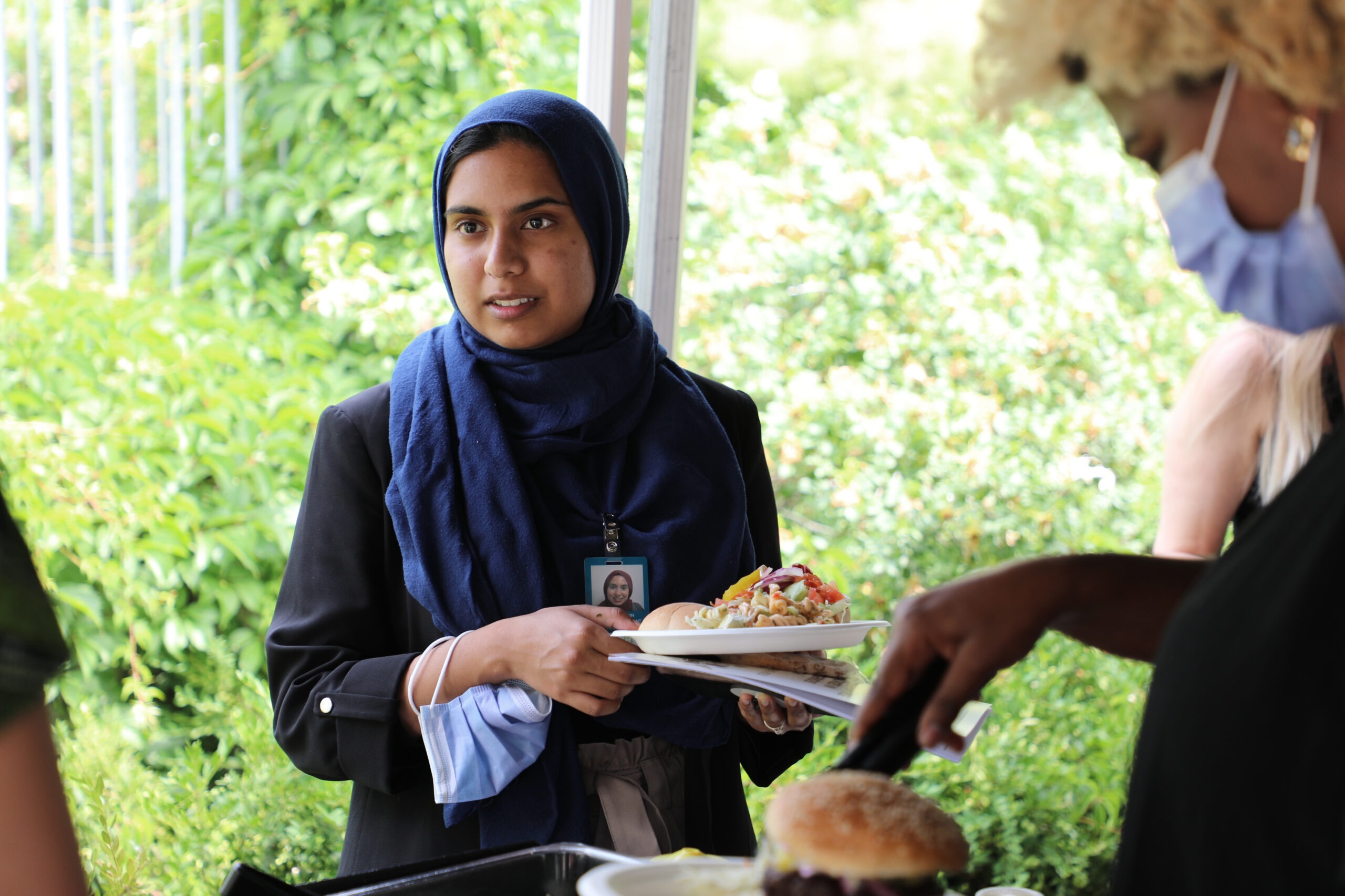 Women's College Hospital Staff BBQ - woman wearing hijab speaks with colleagues