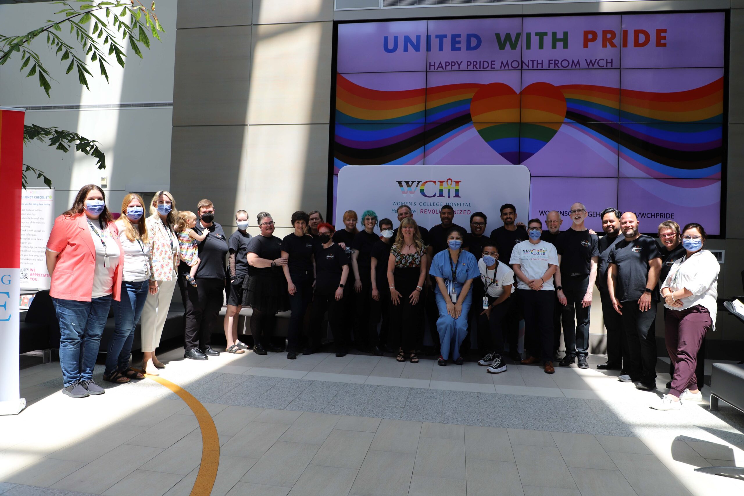 WCH staff and Singing Out: Toronto 2SLGBTQIIA + Choir standing alongside each other smiling