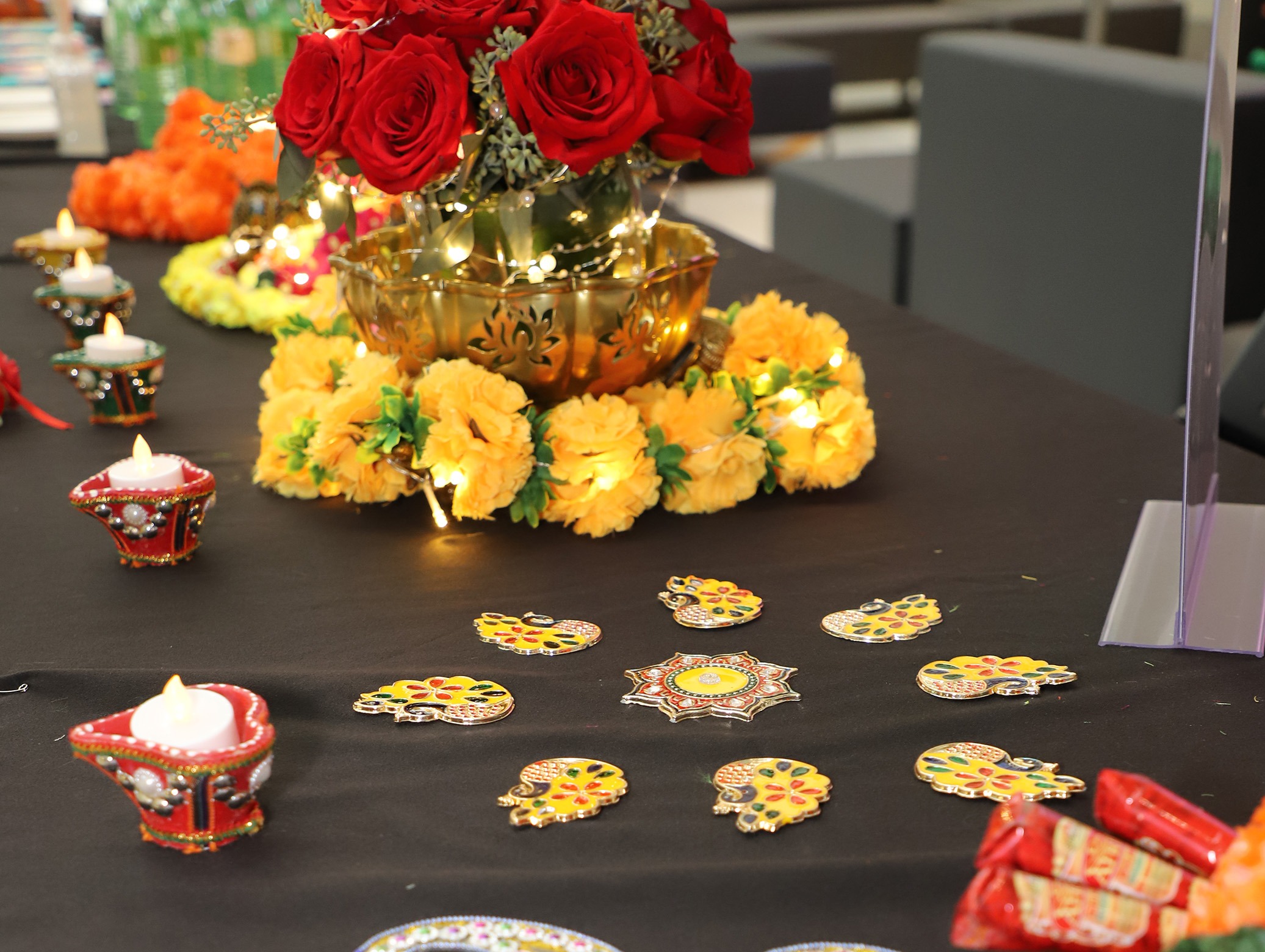 Roses, marigolds and diwali candles on a table